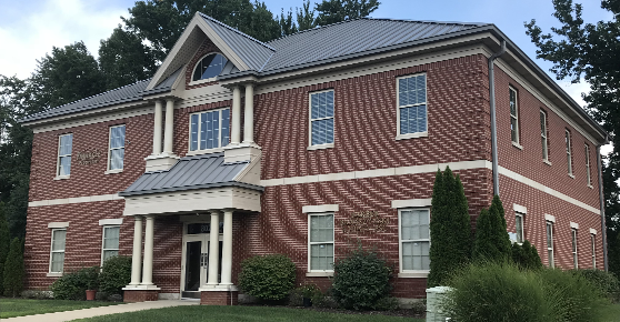 Brick building with concealed fastener metal roof panels 